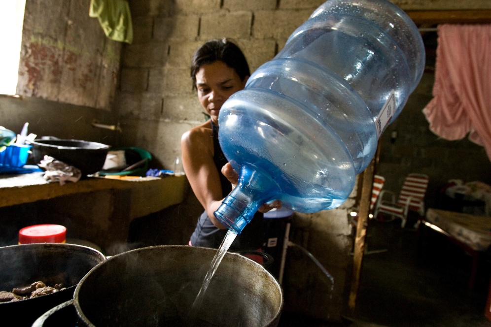 Maria Magdalena Gonzalez cooks with water purified by a bio-sand filter in her home in Bonao, Dominican Republic.