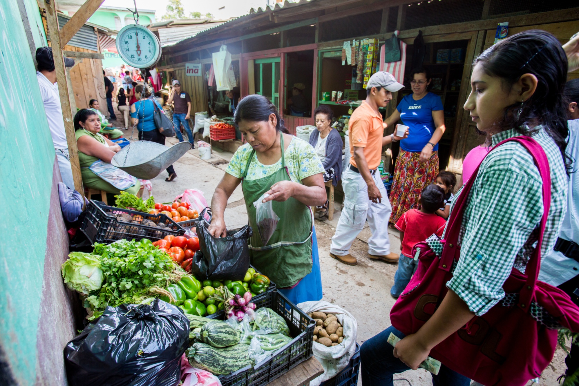 Adelante Foundation microcredit client Dona Ninfa (center) sells vegetables at the market in La Esperanza, Honduras. The Adelante Foundation's microcredit program, which offers women loans and business training aimed at increasing their household incomes.